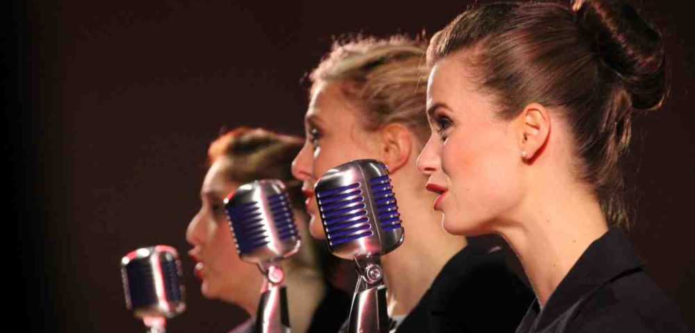 Drei Frauen mit Mikrophon singend