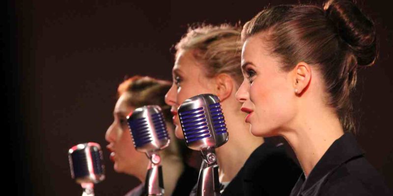Drei Frauen mit Mikrophon singend