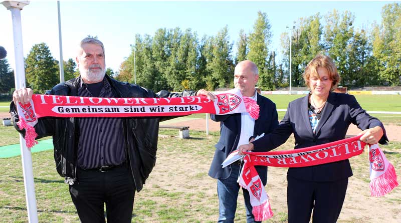 Teltows Bürgermeister Thomas Schmidt nimmt den Zuwendungsbescheid von Ministerin Britta Ernst entgegen. Der Ehrenvorsitzende des Teltower Fußballvereins 1913, Hans-Jürgen Watteroth, übergibt der Ministerin einen Fanschal.